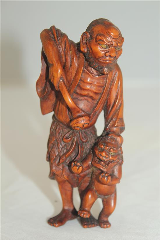 A Japanese boxwood okimono netsuke of a Sennin and a shi-shi, early 20th century, 10.5cm